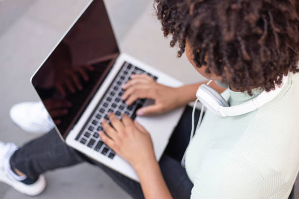 istock College student sitting on the stairs working on a laptop. 1430062056