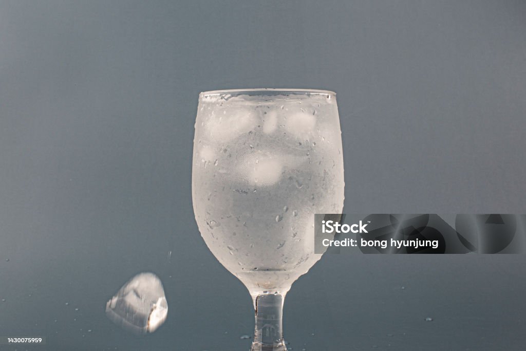 glass of water with ice isolated Blue Stock Photo