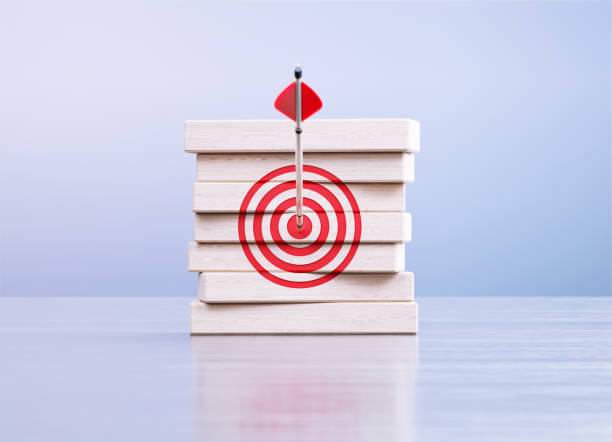 istock Arrow Hitting Red Bull's Eye Target On Wood Blocks in Front a Defocused Background 1430077390
