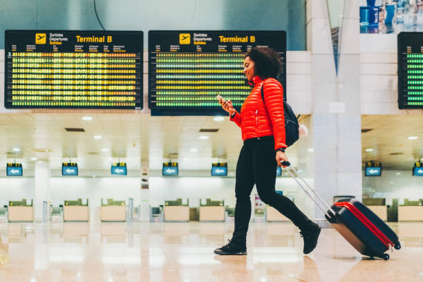 istock Woman using smartphone at the airport terminal 1430078337