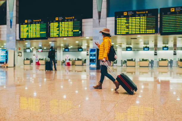 istock Woman using smartphone at the airport terminal 1430078638