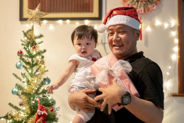 Asian Chinese father celebrating Christmas with baby girl stock photo