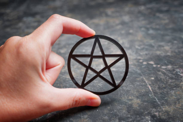istock Black pentagram in hand against dark background 1430085149