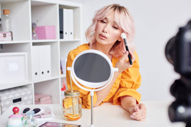 istock Asian woman doing make up in mirror 1430088483