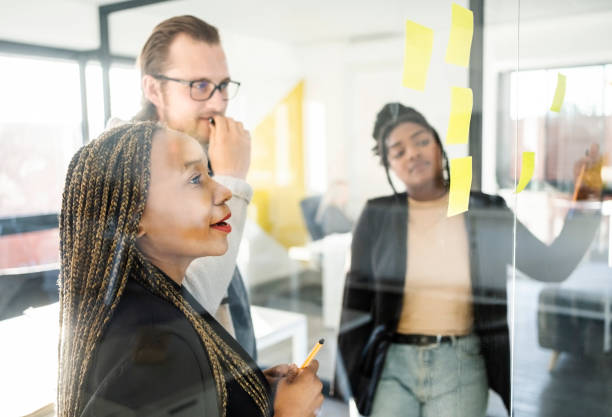 istock Startup business team brainstorming with adhesive notes on a glass wall 1430092875
