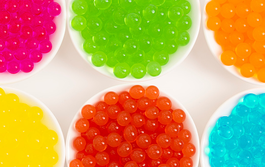 Six Different Flavors of Popping Boba Pearls Isolated on a White Background