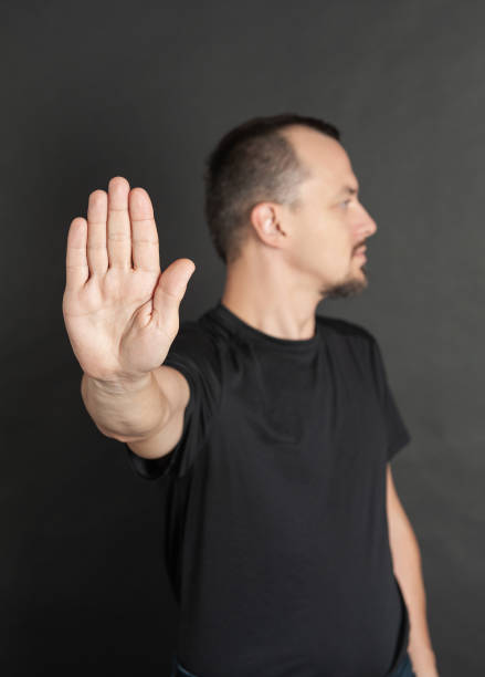 Young handsome man showing stop gesture. Focus on the hand stock photo