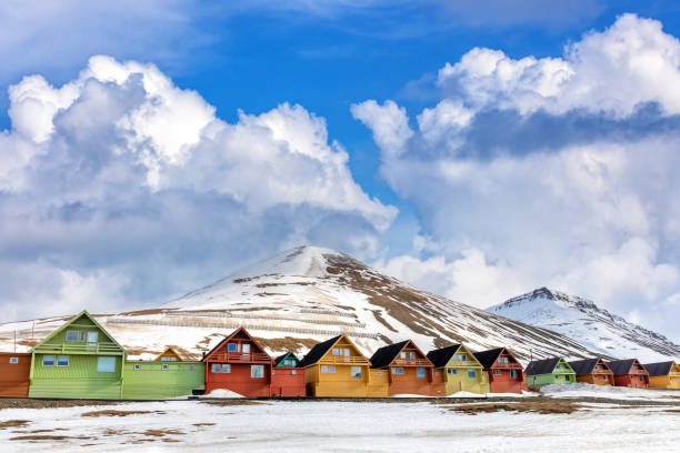 Row of colourful wooden houses in Longyearbyen, Svalbard, the most northerly town in the world. Early spring scene with snow on the mountains and the foreground stock photo