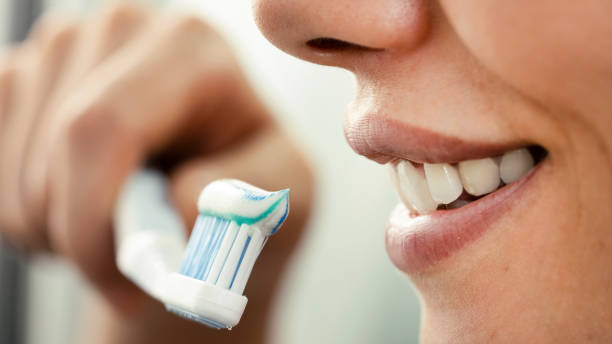 istock Young woman brushing her teeth 1430104615