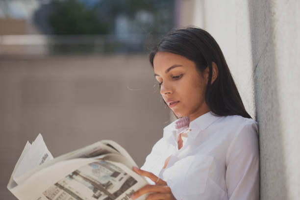 Nice young female student reading old thick book in library