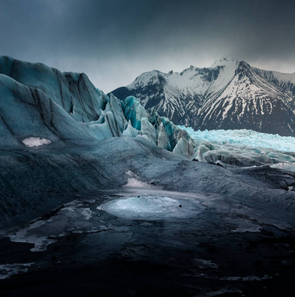 Dramatic and Moody Svinafellsjokull Glacier in Iceland Walking amidst the Svinafellsjokull Glacier in Iceland iceberg dramatic sky wintry landscape mountain stock pictures, royalty-free photos & images