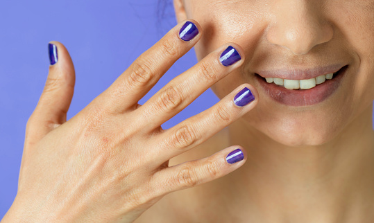 Smiling woman with purple polish.