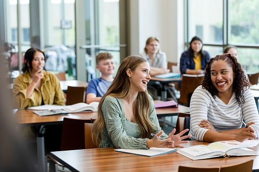 The diverse group of college student attend lecture on campus.