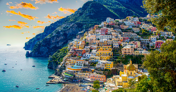 Aerial view of Positano in Italy with a spectacular background of golden clouds and colourful houses on the coast