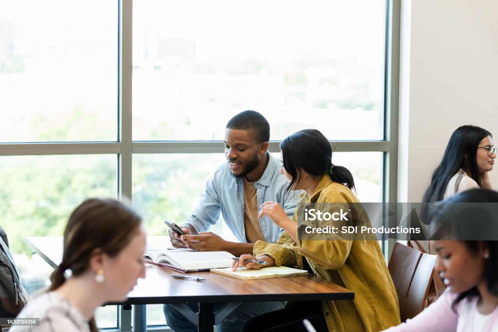 College students help critique essays The college students help critique essays for other peers during class. Multiracial Group Stock Photo