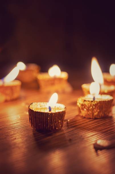 istock Candle with Glowing Flame Lit on Diwali Night with Selective Focus Isolated on Wooden Table with Candlelight Background in Vertical Orientation, Deepavali or Happy Diwali Festival Celebration Conceptual, Perfect for Wallpaper 1430115235