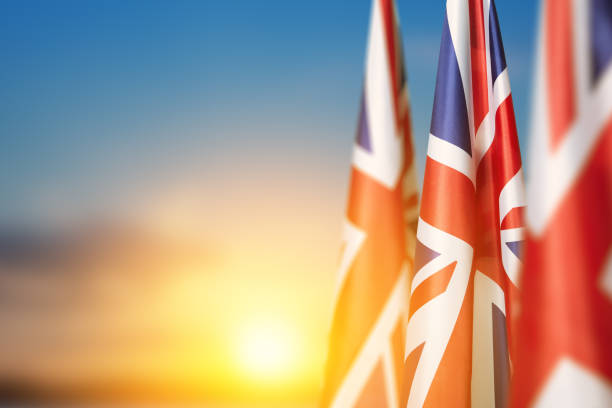 National flags of United Kingdom on a flagpole on sunset sky background. National flags of United Kingdom on a flagpole on sunset sky background. Lowered UK flags. Background with place for your text. 1926 stock pictures, royalty-free photos & images