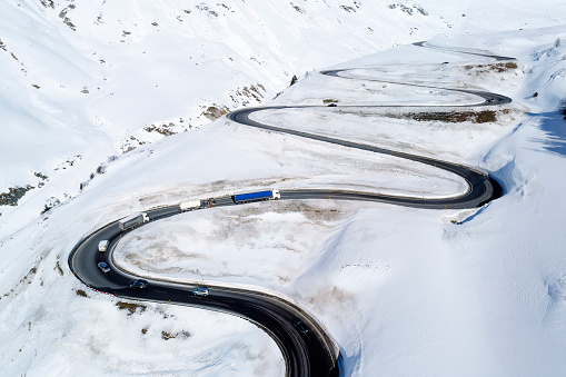 Aerial view of curvy winding road in Julier Pass, cars driving, Swiss Alps, Graubunden Canton (Canton of Grisons).