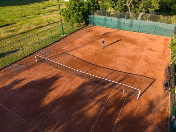istock Boy playing tennis on clay court 1430121112