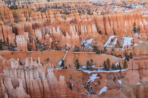 Bryce Canyon National Park after a snowfall. The bright orange hoodoos stick out with the white snow around them.