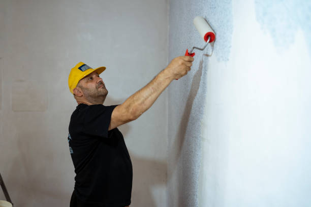 istock Construction worker plastering and smoothing concrete wall in room. 1430127762