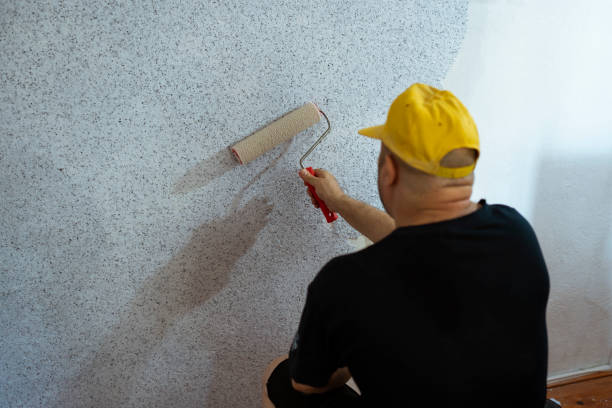 istock Construction worker plastering and smoothing concrete wall in room. 1430127795