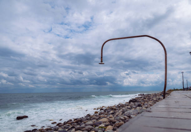 The light or lantern is shining in the dark and placed on the edge of the mortar with sea and twilight sky at night as background.