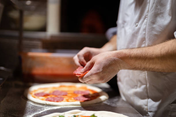istock Male chef hands making pizza in the pizzeria kitchen 1430129545