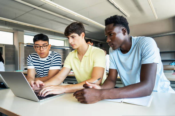 istock Teenager students working together at High School Classroom, doing exercise with laptop 1430133182