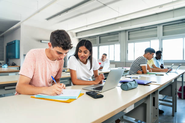 istock Teen latin girl and caucasian guy students talking about class work using laptop computer 1430133379