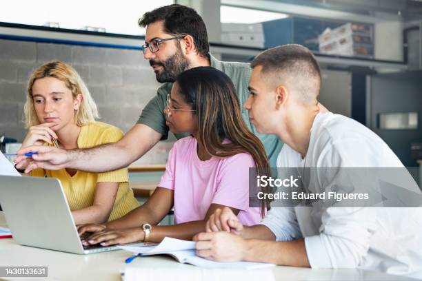 Young Teacher Helping Teenager Students At College Learning Technology And Science In Preparatory Course For University Stock Photo - Download Image Now