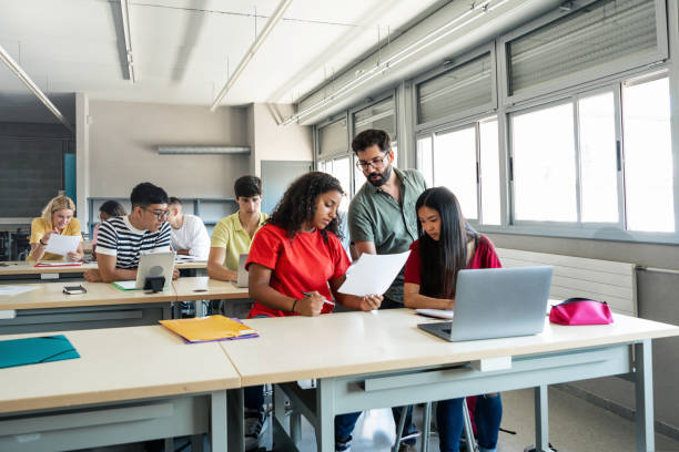 istock High School Classroom - Young teacher explaining exercise to teenager students 1430133814