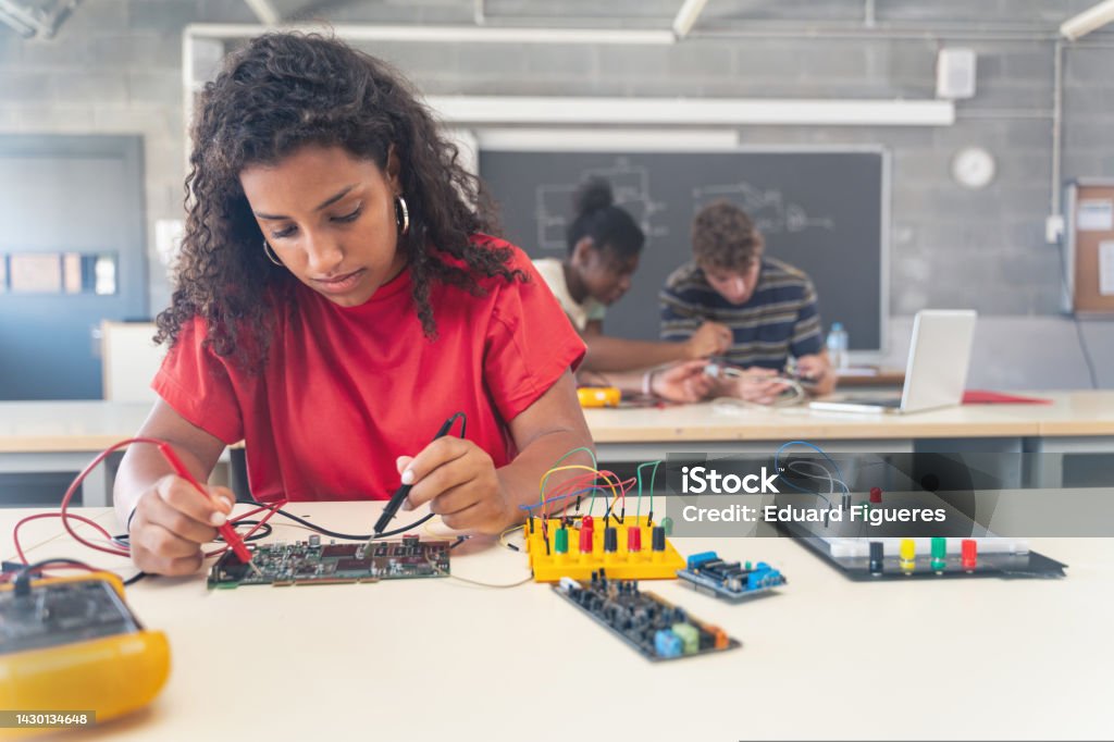 African American female teenager Student working on electronics robotics in the technology course STEM - Topic Stock Photo