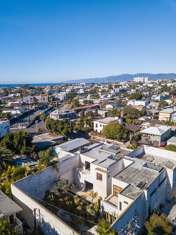 Aerial drone photo of the Venice neighborhood in Los Angeles, California, with views of the Pacific Ocean and Santa Monica mountains in the background.