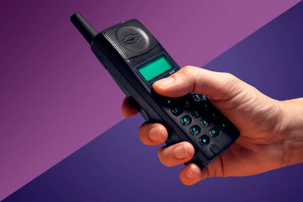 An old, used button-style mobile phone, isolated on a white background.