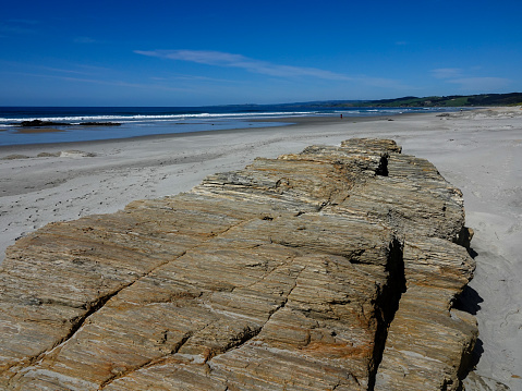 Finely layered boulders on a Southern New Zealand beach.