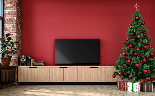 A nostalgic retro living room with a few wrapped gifts under the Christmas decorated tree, with a  blank TV (copy space) and decoration (vases, books, speakers) on a low wooden cabinet in front of an empty red plaster wall with copy space. A partly ruined brick wall with a radiator heater under the window on a side and decoration (potted plant ficus) on the hardwood floor. 3D rendered image.
