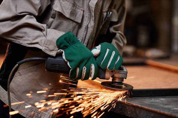 Metal Sanding With Sparks Close up of unrecognizable male worker cutting metal with electric tool in workshop, sparks flying, copy space metalwork stock pictures, royalty-free photos & images