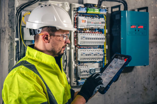 istock Man, an electrical technician working in a switchboard with fuses, uses a tablet. 1430150481
