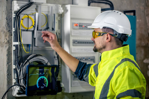 istock Man, an electrical technician working in a switchboard with fuses, uses a tablet. 1430150673