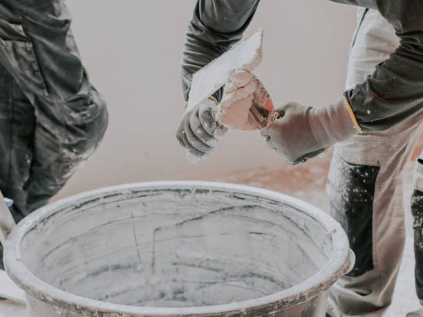 istock A young caucasian guy rakes a white putty with a spatula picking it up from a black basin 1430150764