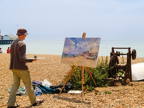Brighton Beach United Kingdom - June 16 2009; Artist painting picturesque  scene on beach