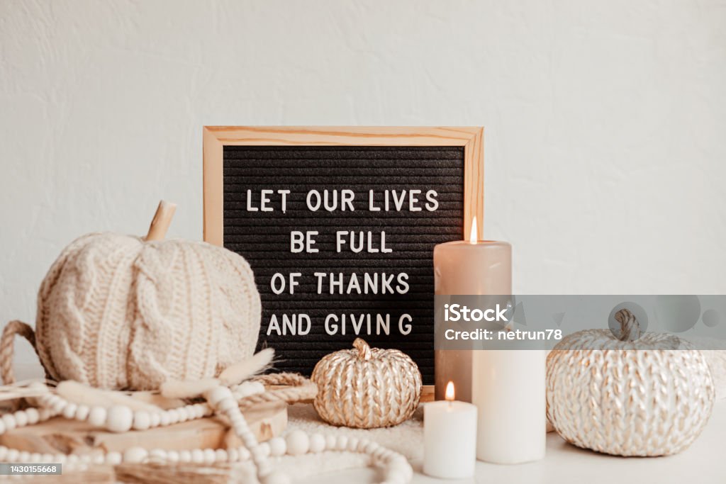 Felt letter board and text let our lives be full of thanks and giving. Autumn table decoration. Interior decor for thanksgiving and fall holidays with handmade pumpkins and candles Thanksgiving - Holiday Stock Photo