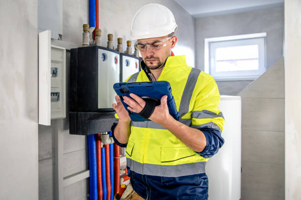 istock Man, an electrical technician working in a switchboard with fuses, uses a tablet. 1430157795