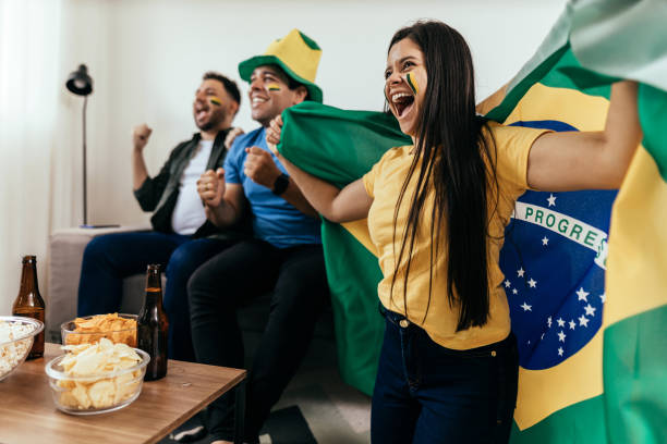 amici tifosi di calcio che guardano la nazionale brasiliana in diretta partita di calcio in tv a casa - fan foto e immagini stock