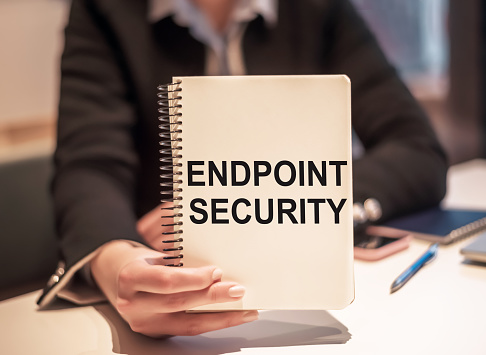 Business woman holds a notebook with the text Endpoint Security.