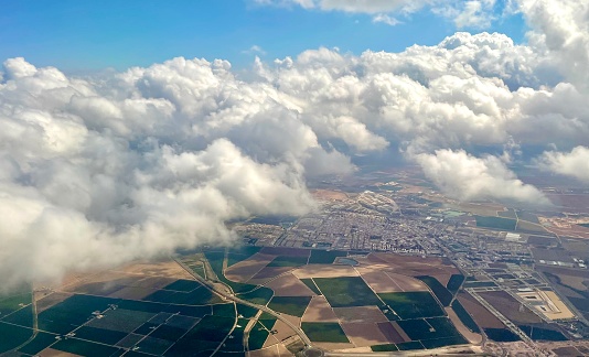 Flying Above the clouds in a plane looking down on farm land in Spain