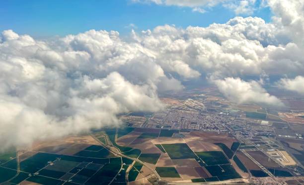 Flying Above the clouds looking down on farm land stock photo