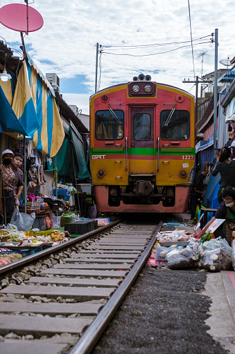 Maeklong Railway Market Thailand, . Train on Tracks Moving Slow. Umbrella Fresh Market on the Railroad Track, Mae Klong Train Station, Bangkok, Thailand on a Sunny Day