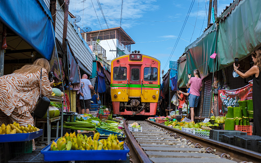 Maeklong Railway Market Thailand, . Train on Tracks Moving Slow. Umbrella Fresh Market on the Railroad Track, Mae Klong Train Station, Bangkok, Thailand on a Sunny Day